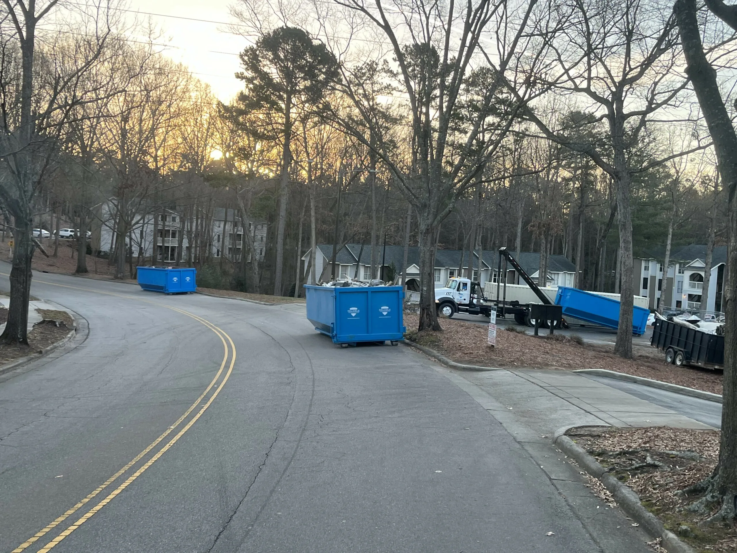 Reliable roll-off containers and truck on a project site